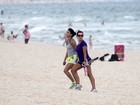 De shortinho, Fernanda Souza caminha na praia com amiga