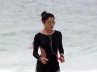 Anna Lima se exercita na praia com shortinho e maiô cavado
