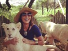 Carol Nakamura posa com filhotes de tigres na África do Sul