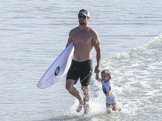 Chris Hemsworth com um dos filhos em praia em Byron Bay, na Austrália (Foto: Grosby Group/ Agência)