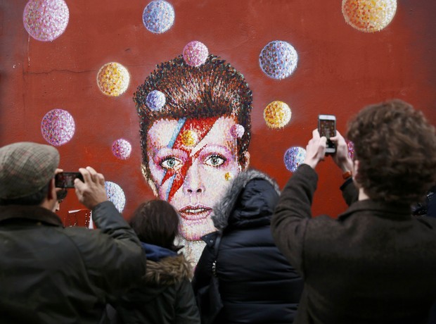 Fãs em mural com pintura do rosto de David Bowie no bairro de Brixton, em Londres (Foto: REUTERS/Stefan Wermuth)