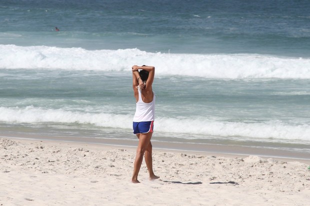 Ana Lima correndo e se alongando na praia da Barra da Tijuca (Foto: Wallace Barbosa/AgNews)