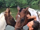 Gisele Bündchen toma banho de rio com cavalos