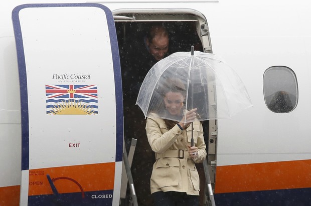 Kate Middleton usa botas de cano alto, calça jeans e casaco bege em dia de chuva na viagem pelo Canadá (Foto: Reuters)