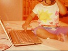 Filha de Max Porto posa com óculos do pai mexendo no computador