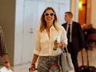 Sorridente, Flávia Alessandra embarca em aeroporto no Rio
