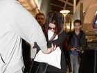 Selena Gomez esconde o rosto com travesseiro ao deixar aeroporto