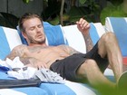 David Beckham relaxa sem camisa à beira da piscina
