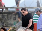 John Travolta joga futebol durante gravação em praia do Rio