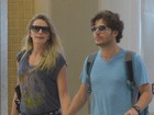 De mãos dadas com a mulher, Erik Marmo embarca em aeroporto do Rio