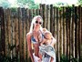 Candice Swanepoel posa de biquíni com o filho de três meses no colo