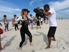 Danielle Winits malha em praia do Rio e depois mergulha de roupa no mar