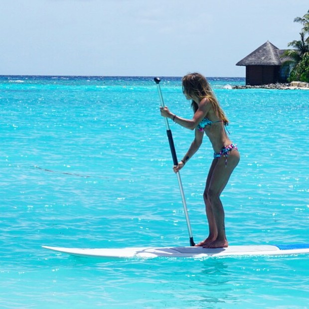 Carol Magalhães pratica stand up paddle em praia nas Maldivas (Foto: Instagram/ Reprodução)