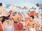Caio Castro se diverte com amigos e tira foto com fã em praia no Rio