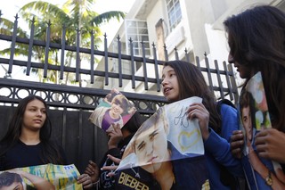 Fãs seguram cartazes de Justin Bieber na porta do hotel onde ele estaria hospedado em Miami (Foto: Reuters)