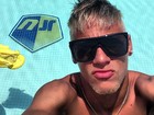 De barba e cabelos loiros, Neymar curte piscina com seu nome no fundo