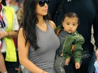 Kim Kardashian viaja com a filha descalça no colo