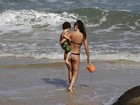 Daniele Suzuki exibe boa forma em dia de praia com o filho e o pai