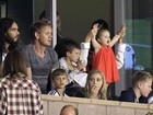 Em estádio, Harper torce pelo pai David Beckham no colo de Victoria 