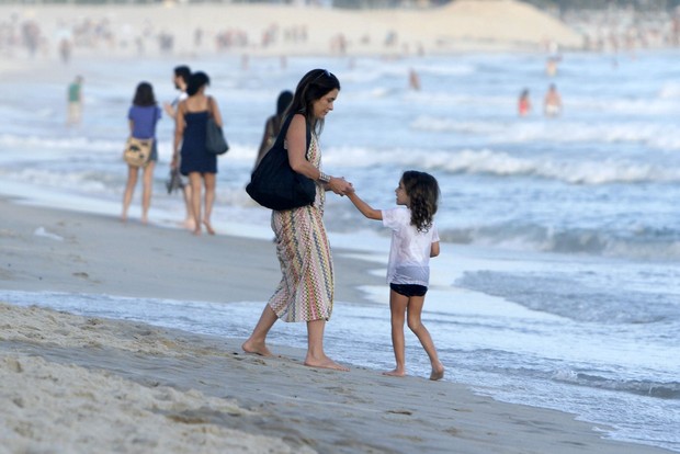 Claudia Abreu passeia com um das filhas na praia (Foto: FotoRioNews)