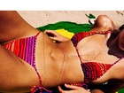 Candice Swanepoel curte praia em canga com a bandeira do Brasil