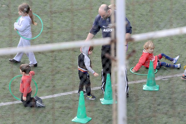 Milan se diverte com outras crianças e recreador em campo de futebol (Foto: Grosby Group)