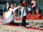 Carla Marins brinca com o filho na orla da praia da Barra da Tijuca