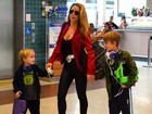 Com os filhos, Danielle Winits usa look decotado para embarcar no Rio