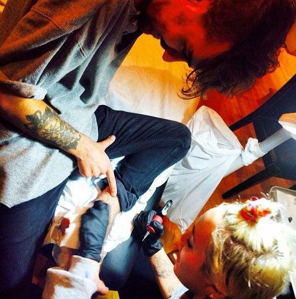 Miley Cyrus tatuando o amigo (Foto: Instagram/Reprodução)