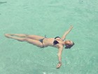 Namorada de Daniel Alves relaxa na piscina e posta foto de biquíni
