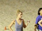 Carolina Dieckmann malha na praia com macacão coladinho
