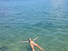 Ex-BBB Adriana relaxa no mar do litoral paulista