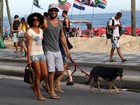 Sorridente, Sheron Menezzes passeia com o namorado e o cachorro no Rio