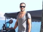 Daniel Oliveira usa blusa cavada para passeio na praia