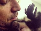 Latino acorda com macaco de estimação grudado no pescoço