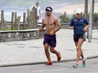 Sem camisa, Juliano Cazarré corre na praia com a mulher