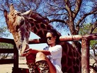 De pernas de fora, Rihanna posa com animais na África