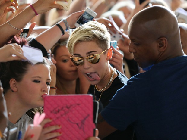 Miley Cyrus é recebida por fãs em rádio em Londres, na Inglaterra (Foto: Splash News/ Agência)