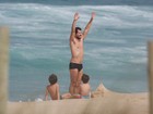 Daniel de Oliveira curte praia no Rio com os filhos e dá cambalhota