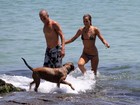Alice Dellal passeia na praia com namorado e cachorro