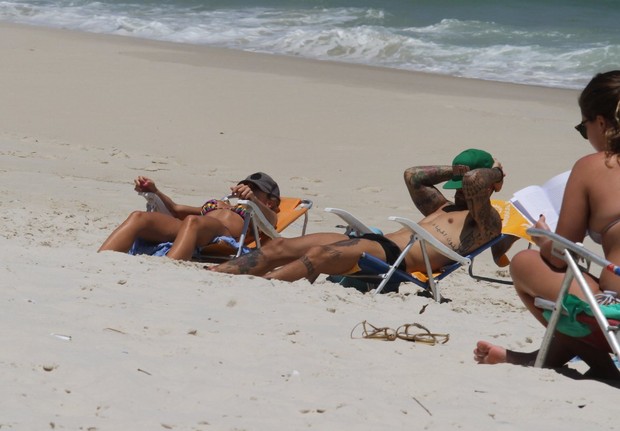 Felipe Tito e namorada na praia da Barra da Tijuca, RJ (Foto: Henrique Oliveira / FotoRioNews)