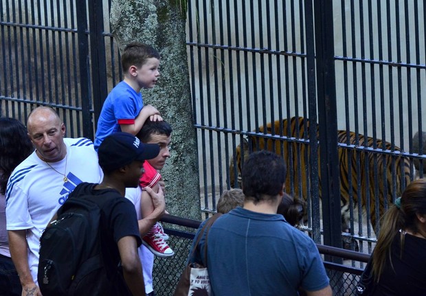 Filho de Wayne Rooney vê o tigre na jaula em zoológico no Rio (Foto: ANDRÉ FREITAS E HENRIQUE OLIVEIRA/AGNEWS)
