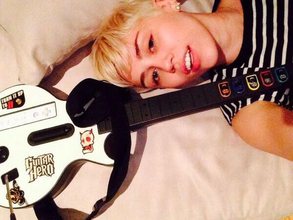 Miley Cyrus posa com guitarra de brinquedo (Foto: Facebook/ Reprodução)