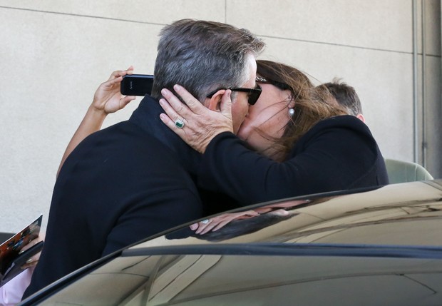 Pierce Brosnan dá beijão na mulher em aeroporto (Foto: Grosby Group)