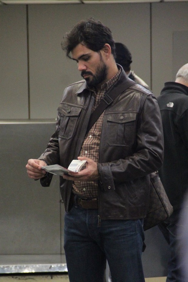 Juliano Cazarré confere seu passaporte (Foto: Rodrigo dos Anjos/Ag News)