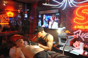 Di Ferrero fazendo tatuagem com Mariana Rios no telão (Foto: Bia Alves /AgNews)
