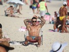De sunga, Felipe Titto mostra tatuagens durante banho de mar