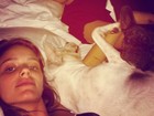 Laura Neiva posa na cama com o namorado e os cachorros: 'Família'
