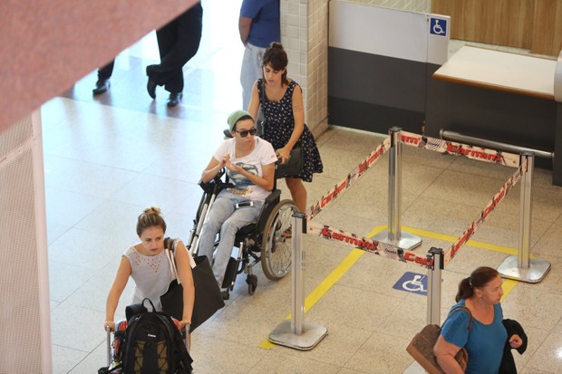 De cadeira de rodas, Maria Gadu embarca com namorada no aeroporto (Foto: Marcello Sa Barretto / AgNews)