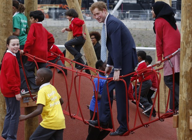 Principe Harry brincando de balanço com as crianças (Foto: Reuters/Agência)